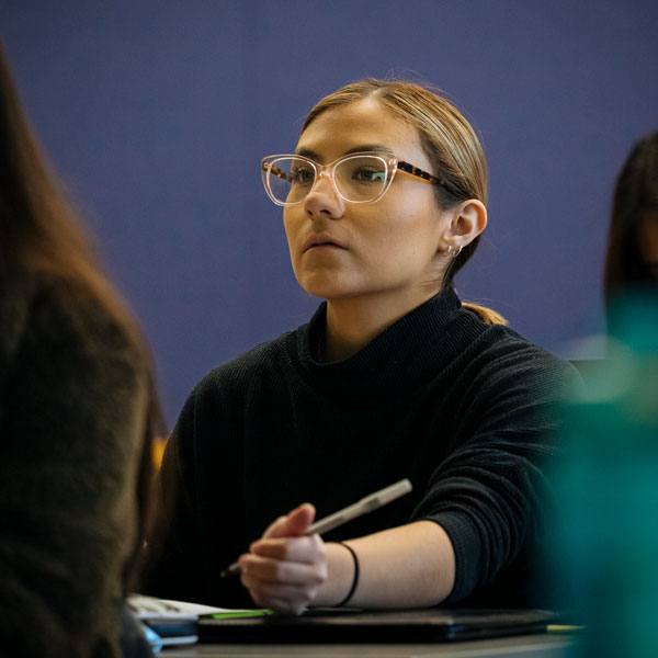 A Human Rights minor student listens and takes notes during class.