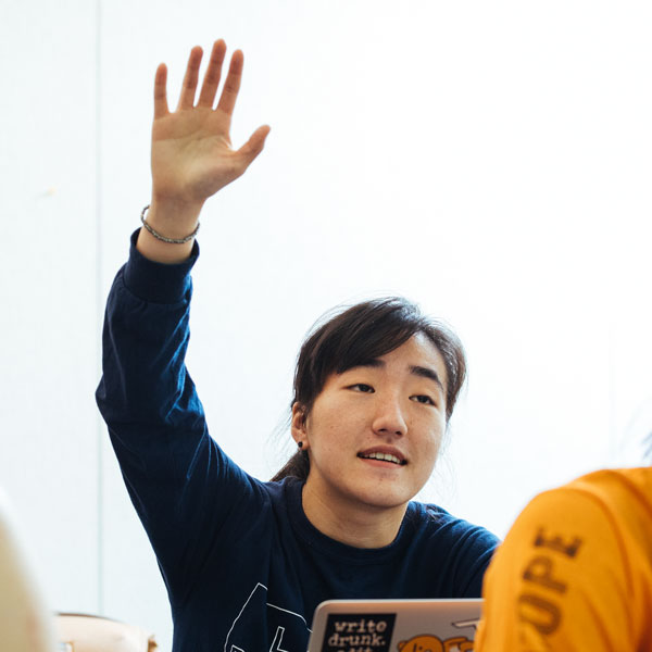 A German Studies major student raises her hand in class.