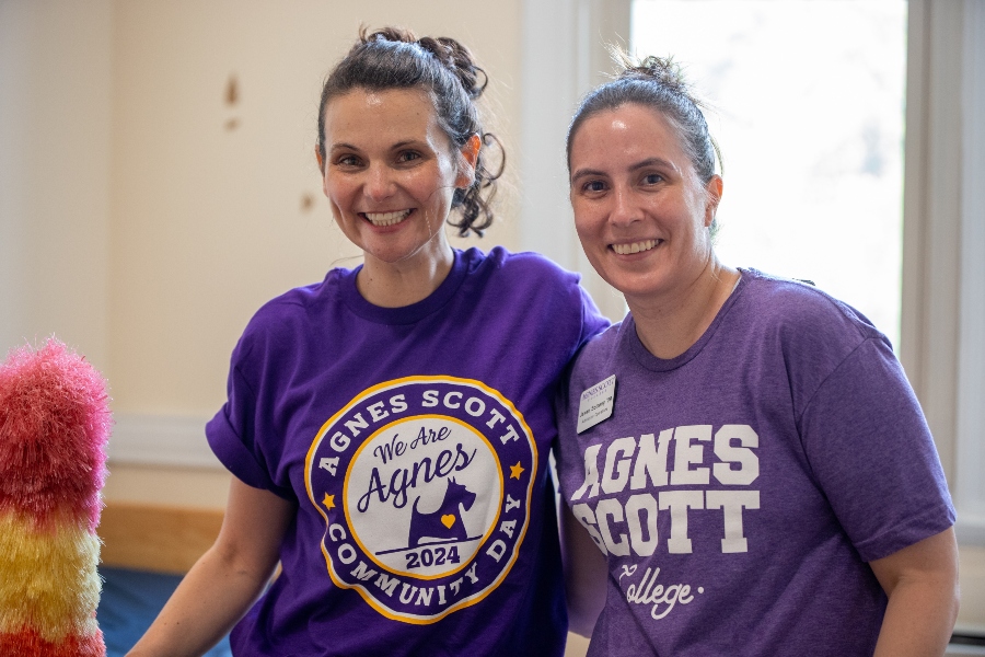 two people pose for a photo wearing purple shirts