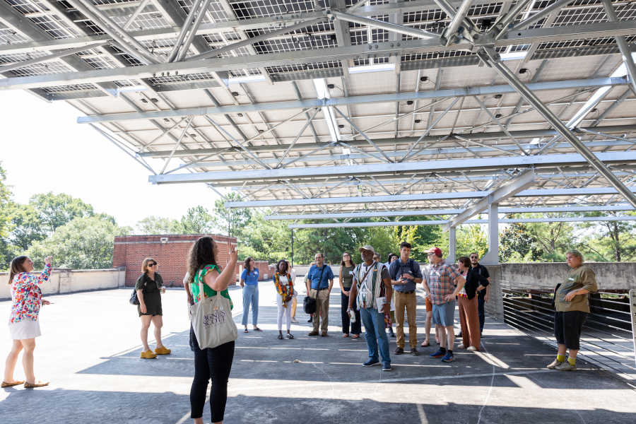 group of people on a tour under solar array