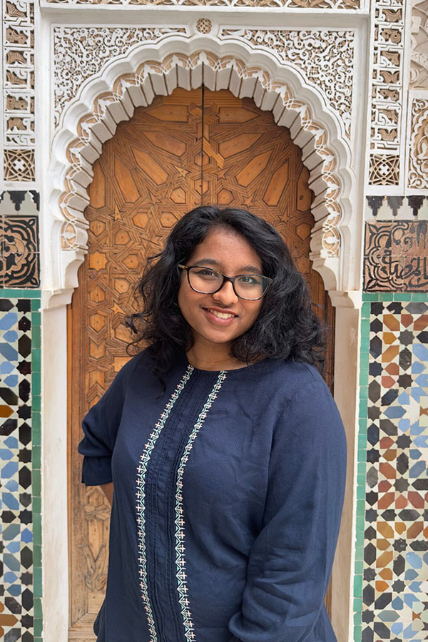 student posing at site on global journey