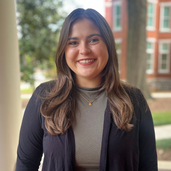 a headshot of Abby Smithwich on a porch of a building