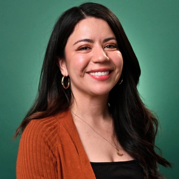 a headshot of a woman in front of a green background